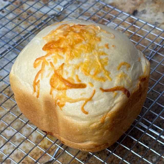 Bread machine cheese bread on a wire cooling rack.