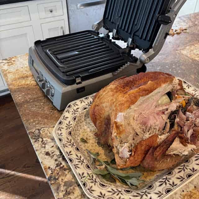 Leftover Thanksgiving turkey on a plate next to a panini press.