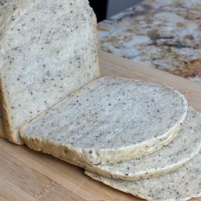 Slices of 1 lb bread machine chia seed bread on wooden cutting board.