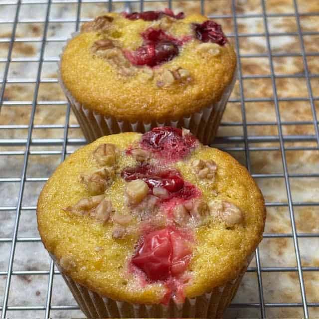 Cranberry walnut orange muffins on a wire cooling rack.