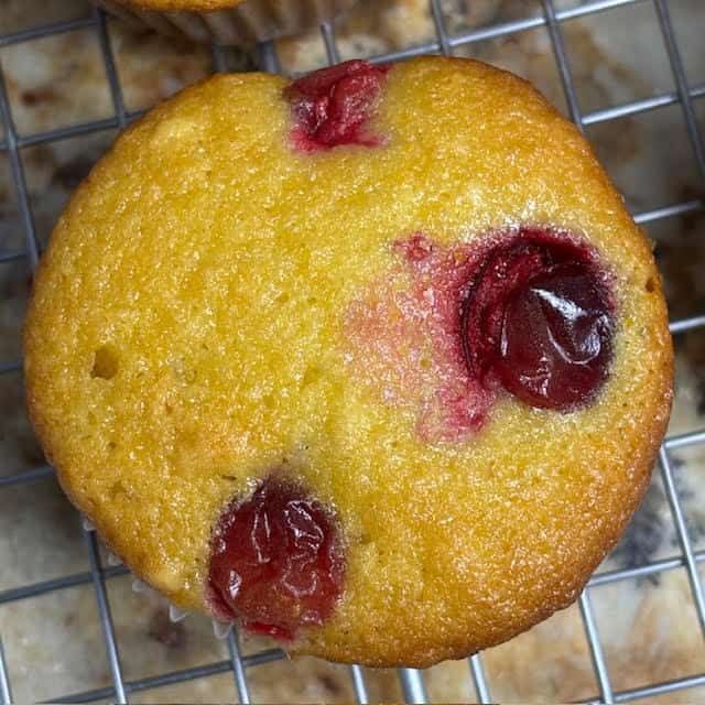 Cranberry orange muffins on wire cooling rack.