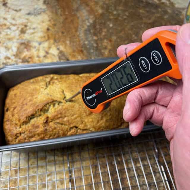 Digital bread thermometer testing the internal temperature of a banana bread.