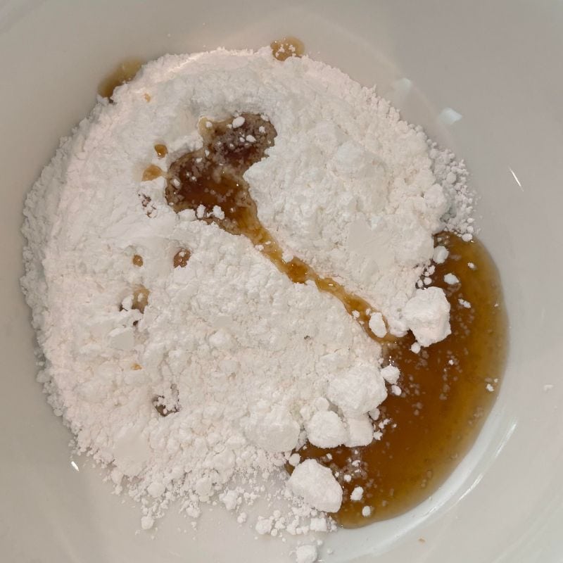 A bowl with powdered sugar and maple syrup.