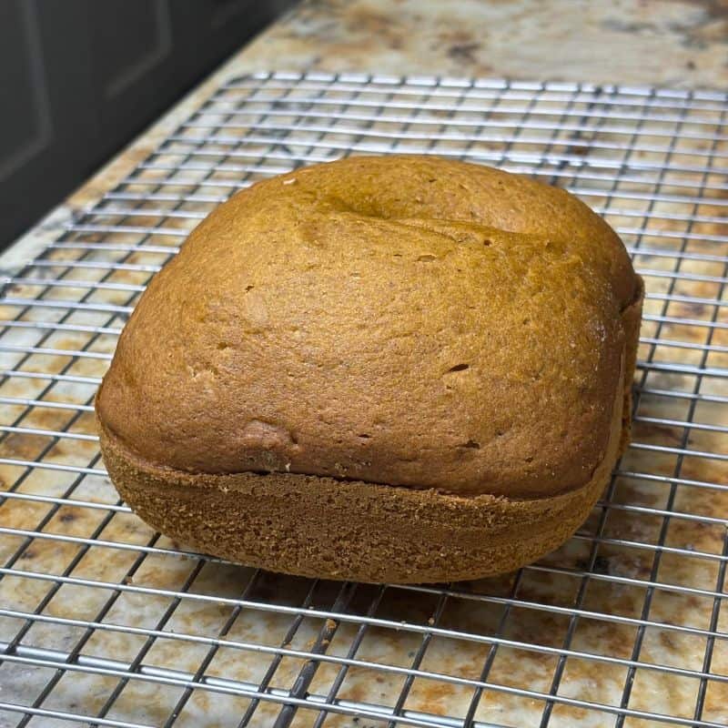 Small bread maker pumpkin bread on a wire cooling rack.