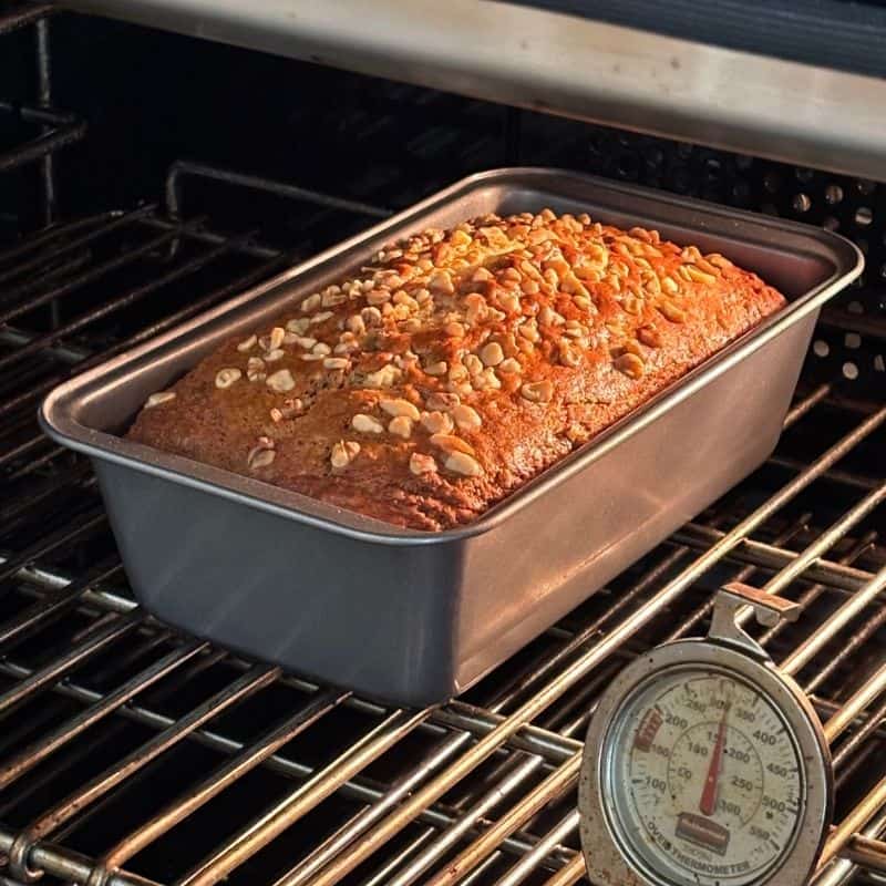 2 banana nut bread in a bread pan in an oven.